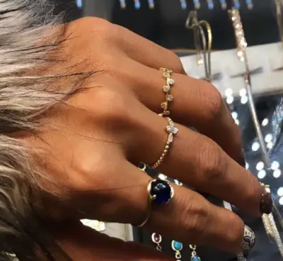 Semih Saraçoğlu tarafından tasarlanan çoklu yüzüklerle süslenmiş bir kadın eli.